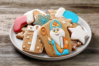 Tasty gingerbread cookies on wooden table, closeup. St. Nicholas Day celebration