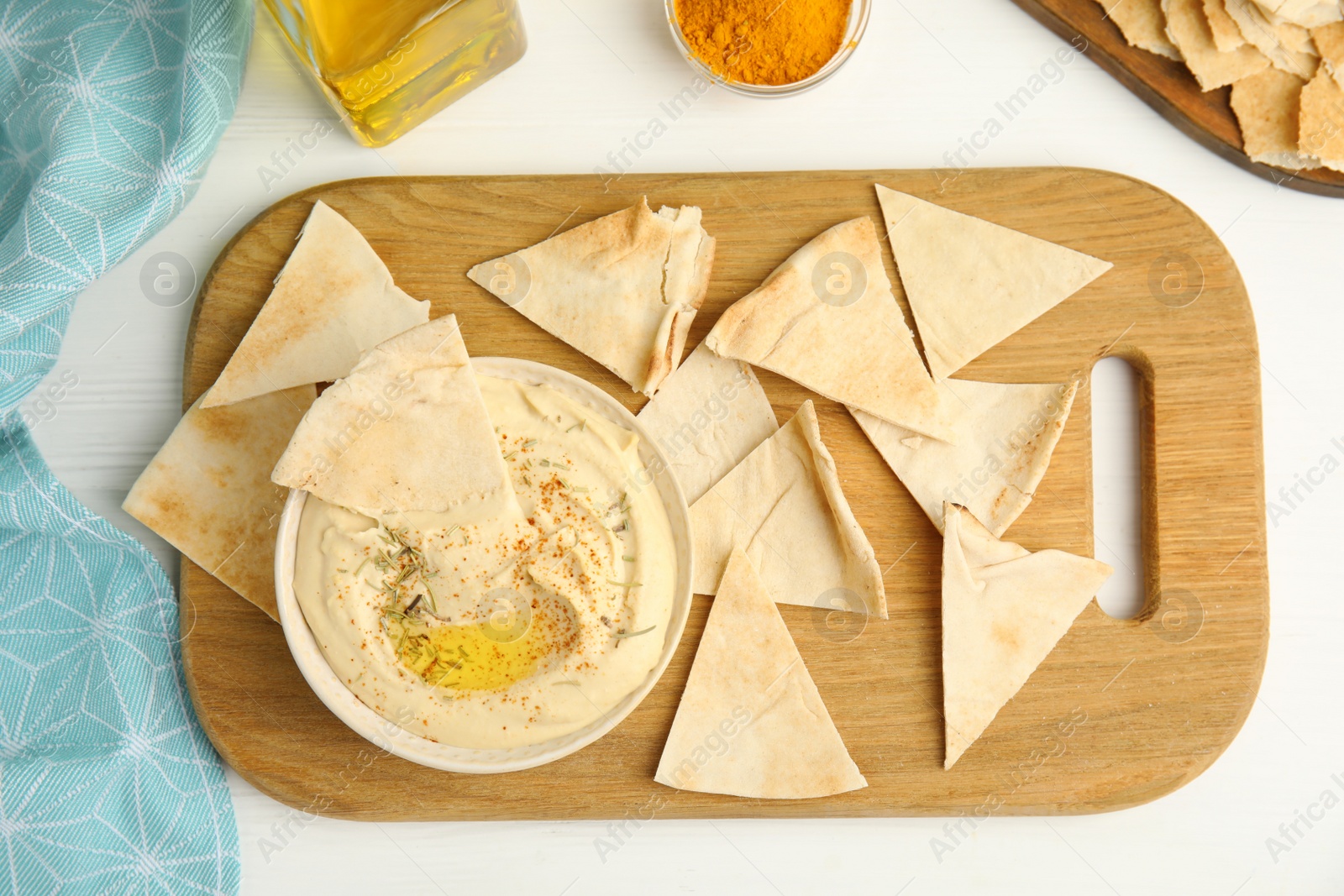 Photo of Delicious hummus with pita chips on white wooden table, flat lay