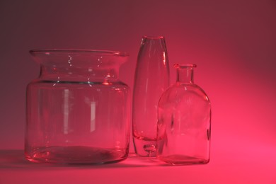 Photo of Different stylish vases on pink background, color tone effect