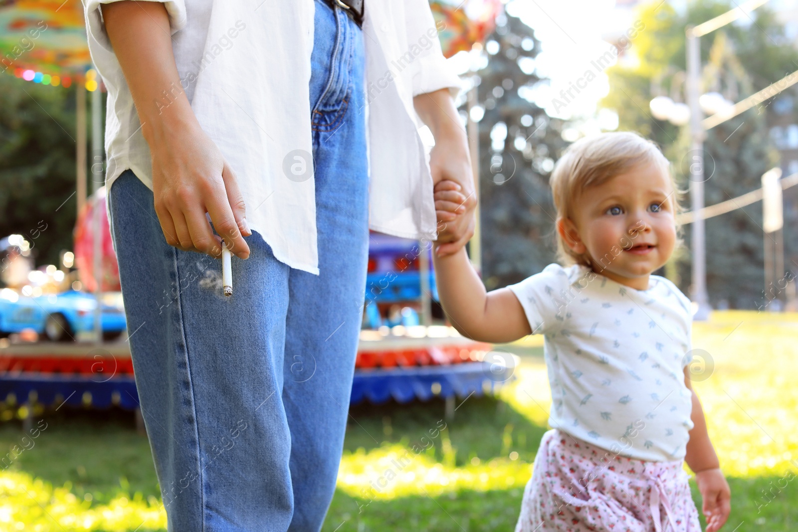 Photo of Mother with cigarette and child outdoors, closeup. Don't smoke near kids