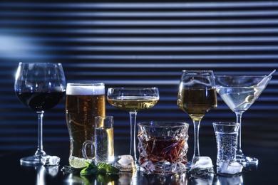Many different alcoholic drinks on table against dark background