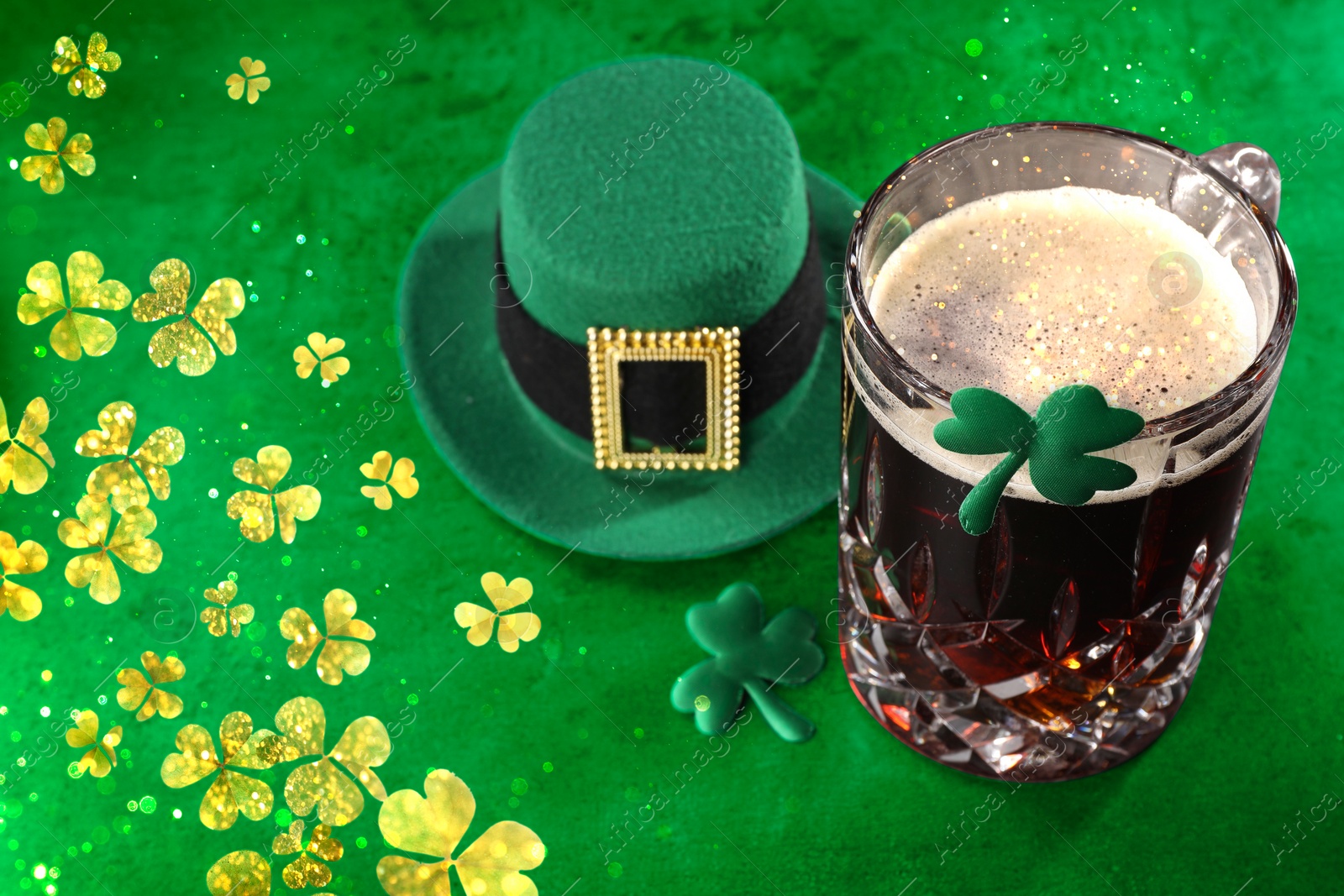 Image of St. Patrick's day. Beer, decorative clover leaves and leprechaun hat on green table, space for text