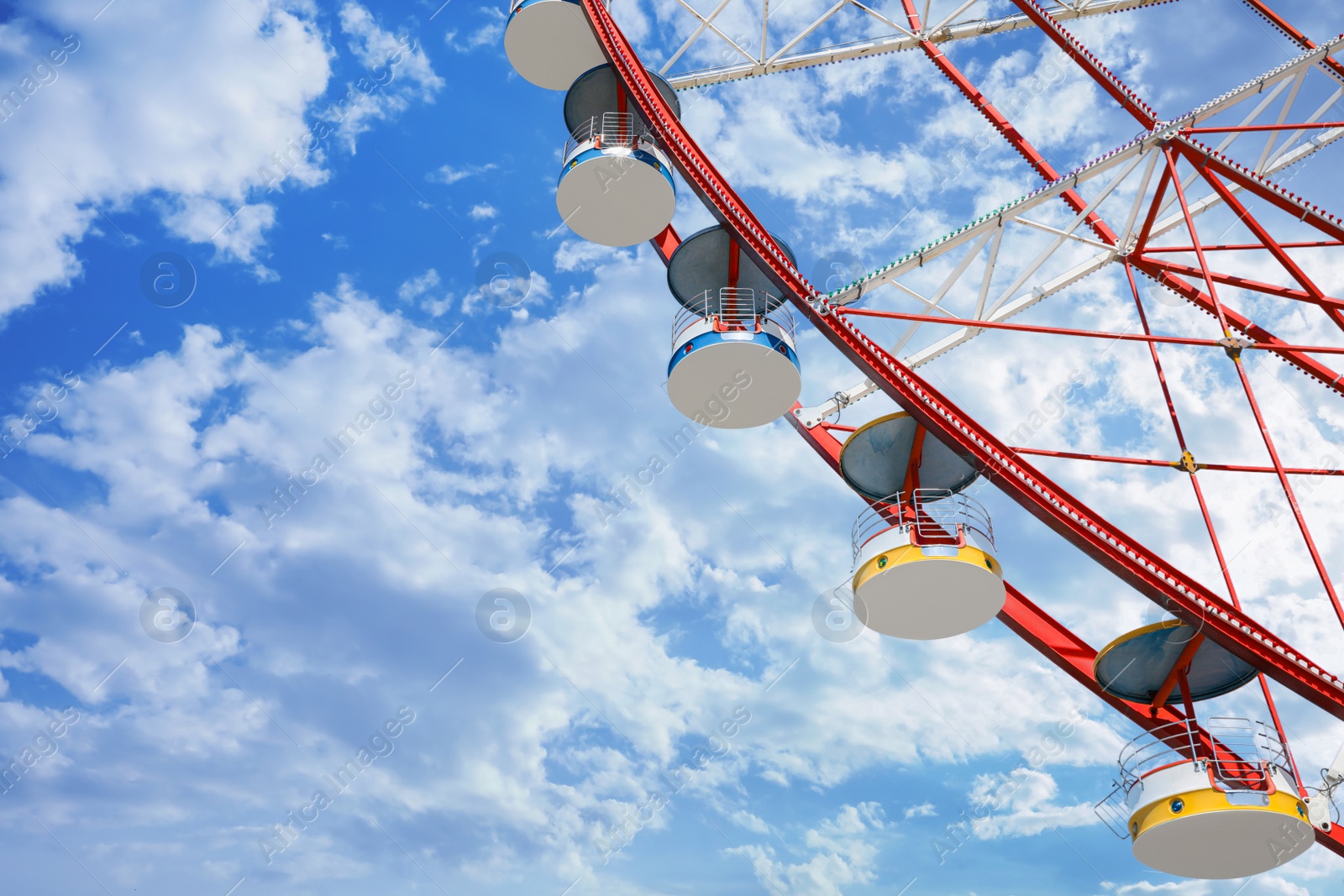 Photo of Beautiful large Ferris wheel against blue sky, low angle view