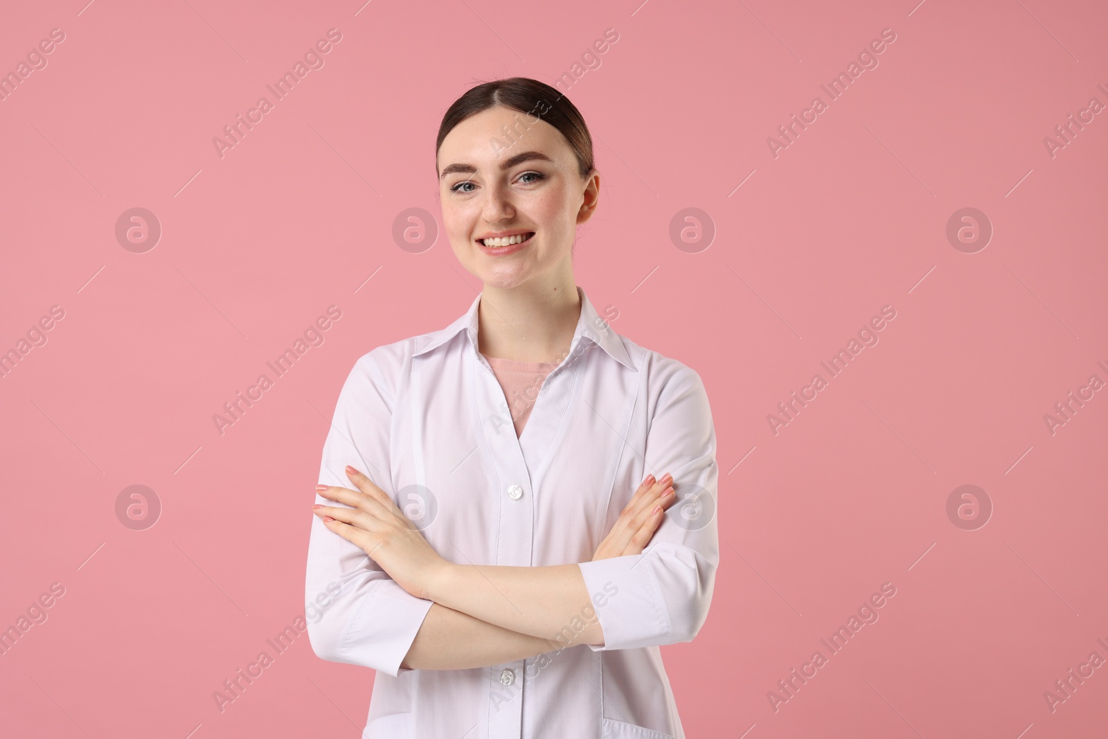 Photo of Cosmetologist in medical uniform on pink background