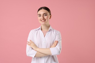 Cosmetologist in medical uniform on pink background