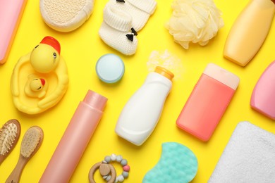 Photo of Flat lay composition with baby cosmetic products on yellow background