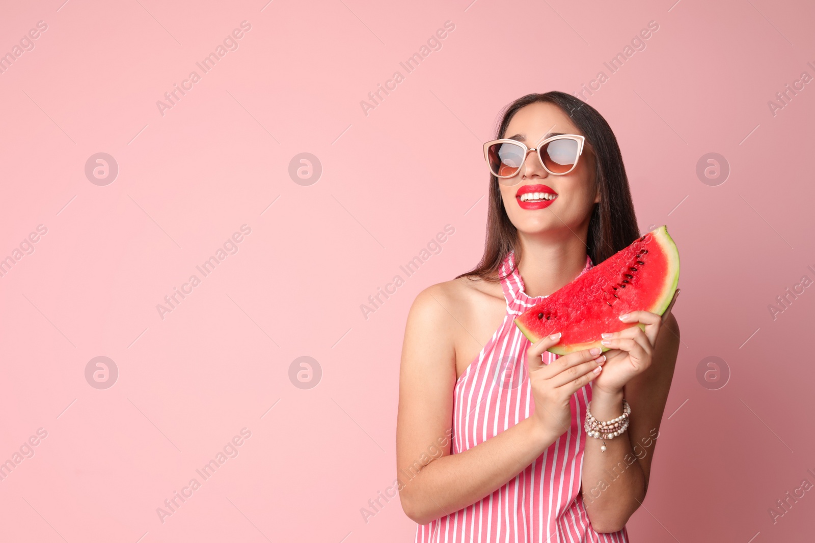 Photo of Beautiful young woman posing with watermelon on color background