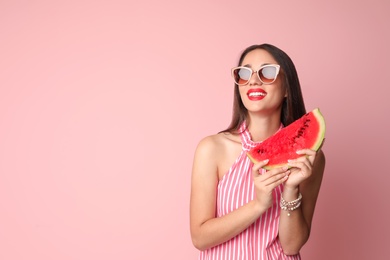 Photo of Beautiful young woman posing with watermelon on color background