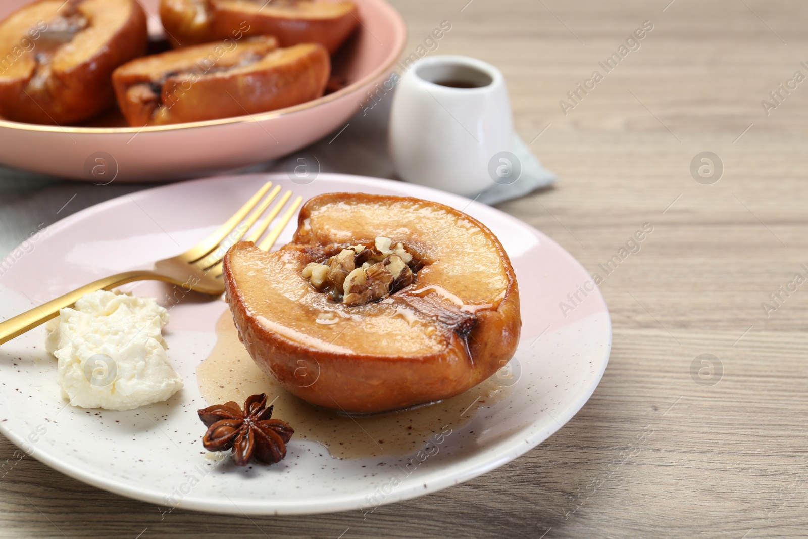 Photo of Delicious quince baked with honey and walnuts on wooden table