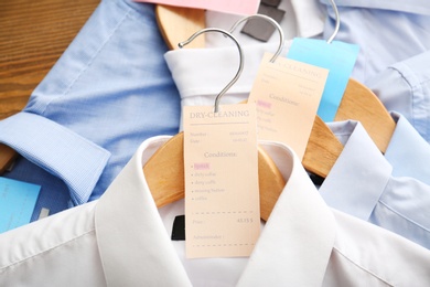 Photo of Clean clothes after dry-cleaning on table