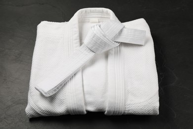 Photo of White karate belt and kimono on gray background