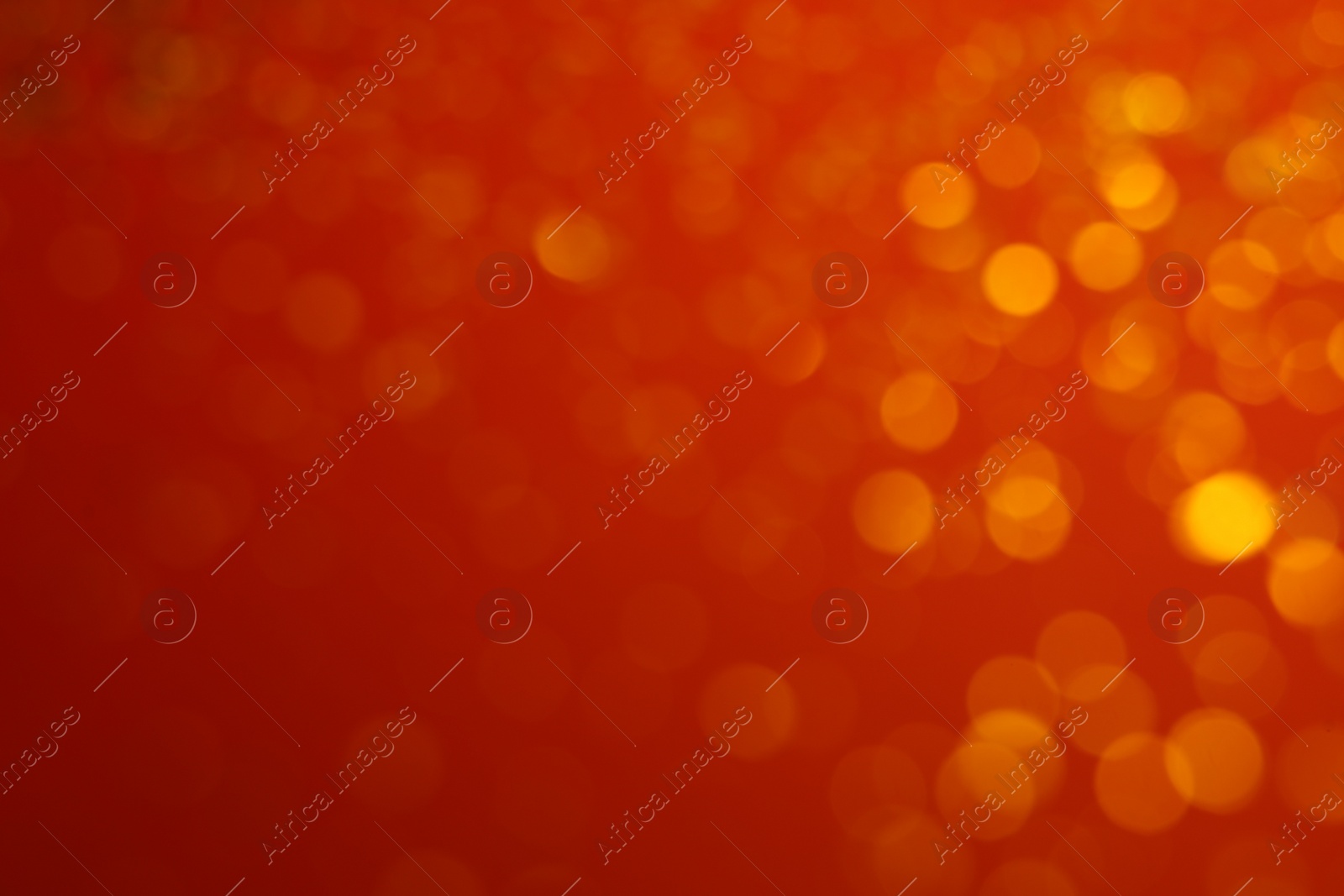 Photo of Blurred view of golden lights on red background. Bokeh effect