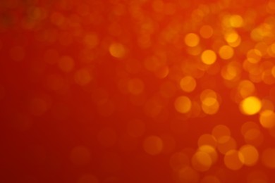 Photo of Blurred view of golden lights on red background. Bokeh effect