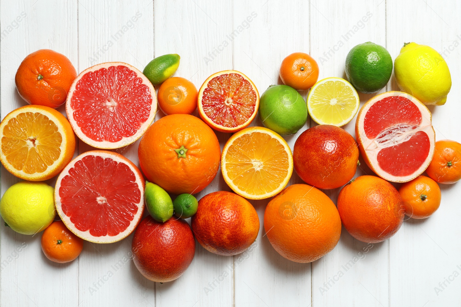 Photo of Flat lay composition with different citrus fruits on white wooden background