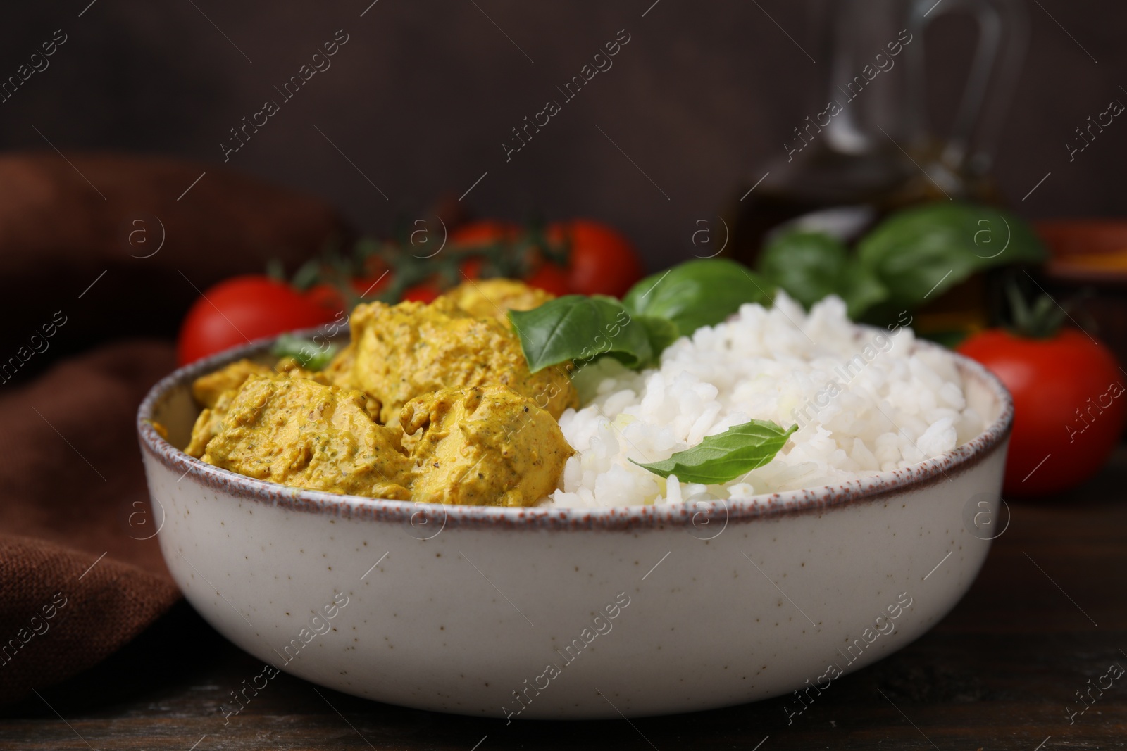 Photo of Delicious rice and chicken with curry sauce on wooden table, closeup