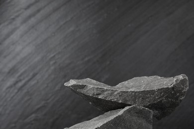 Photo of Presentation for product. Podium made of stones on grey textured background. Space for text