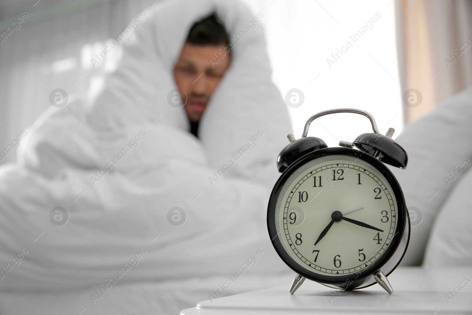 Photo of Alarm clock and man at home in morning. Space for text