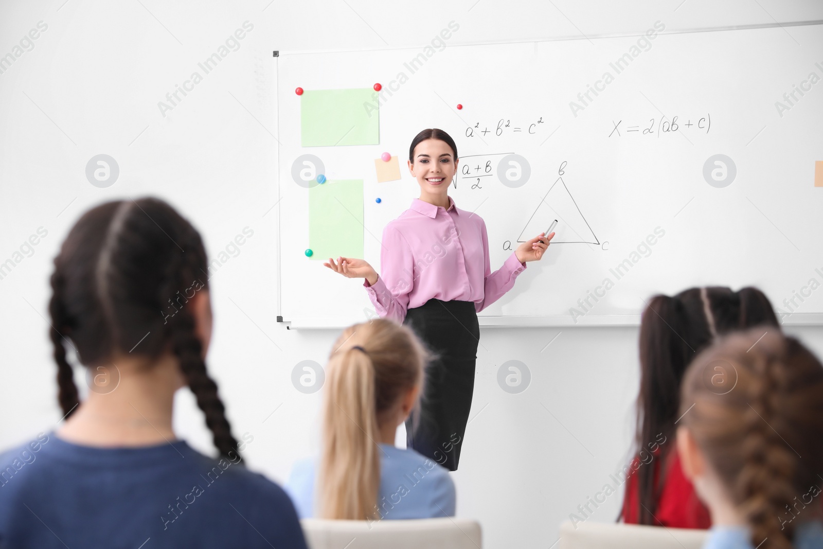 Photo of Young teacher and students in modern classroom