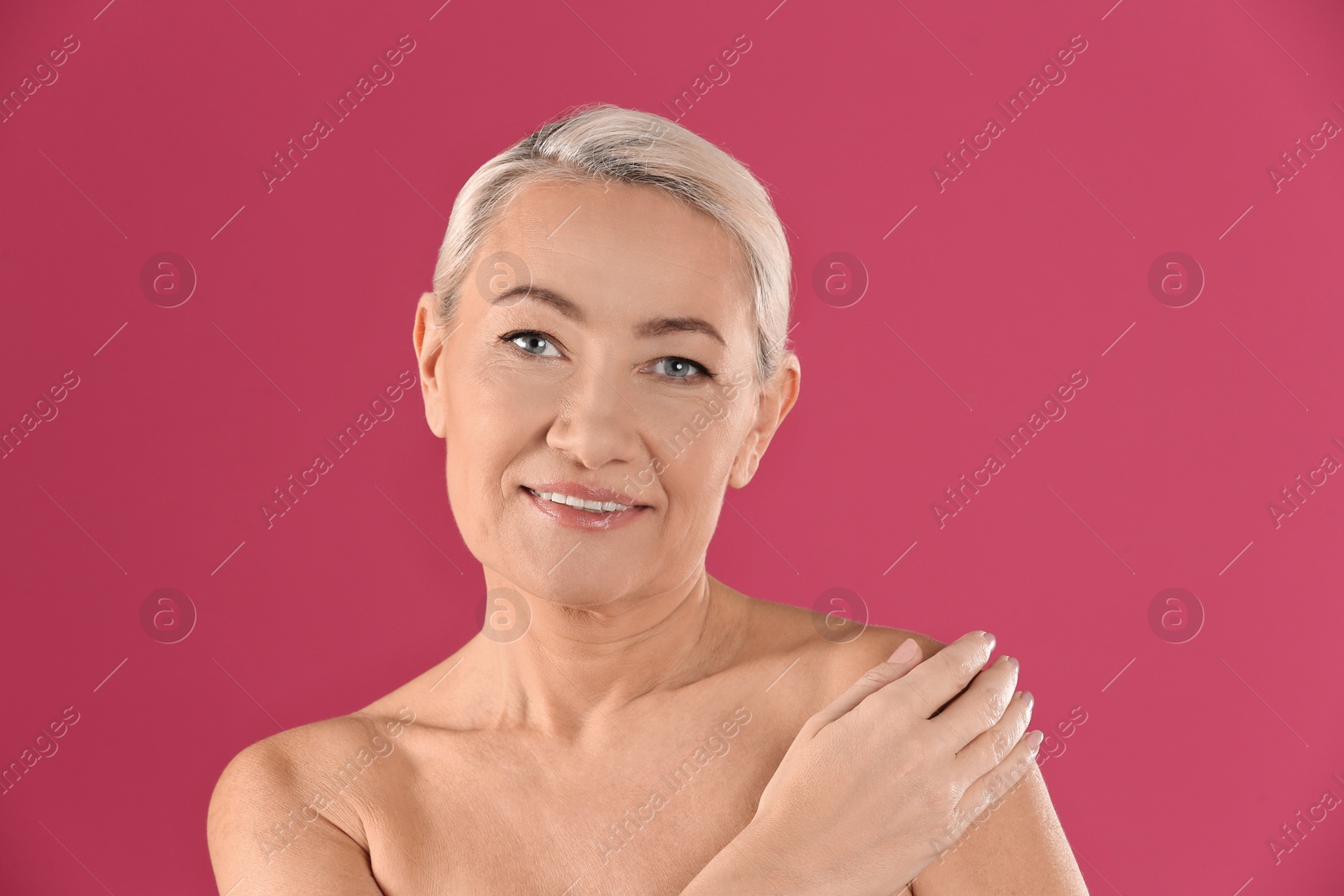 Photo of Portrait of beautiful mature woman on pink background