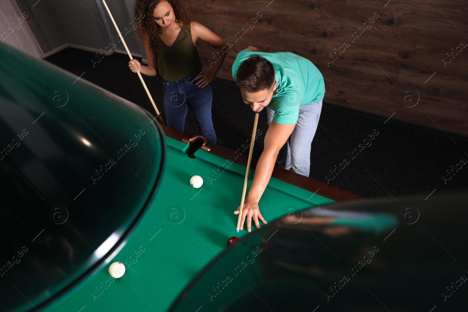 Photo of Young man and woman playing billiard indoors, above view