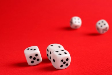 Photo of Many white game dices falling on red background. Space for text