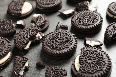 Photo of Tasty chocolate cookies with cream on grey background