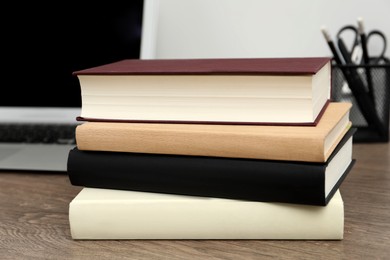 Stack of hardcover books on wooden table indoors, closeup