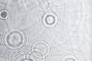 Photo of Closeup view of water with circles on light background