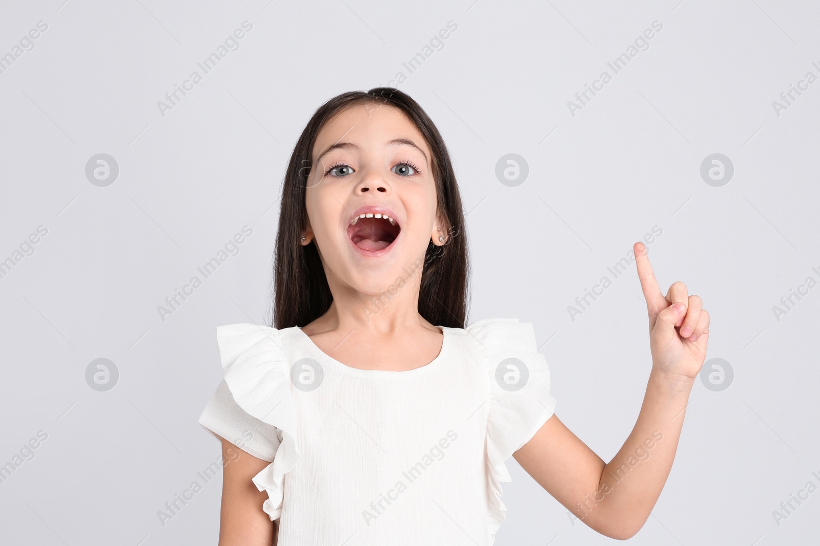 Photo of Portrait of cute little girl on light grey background