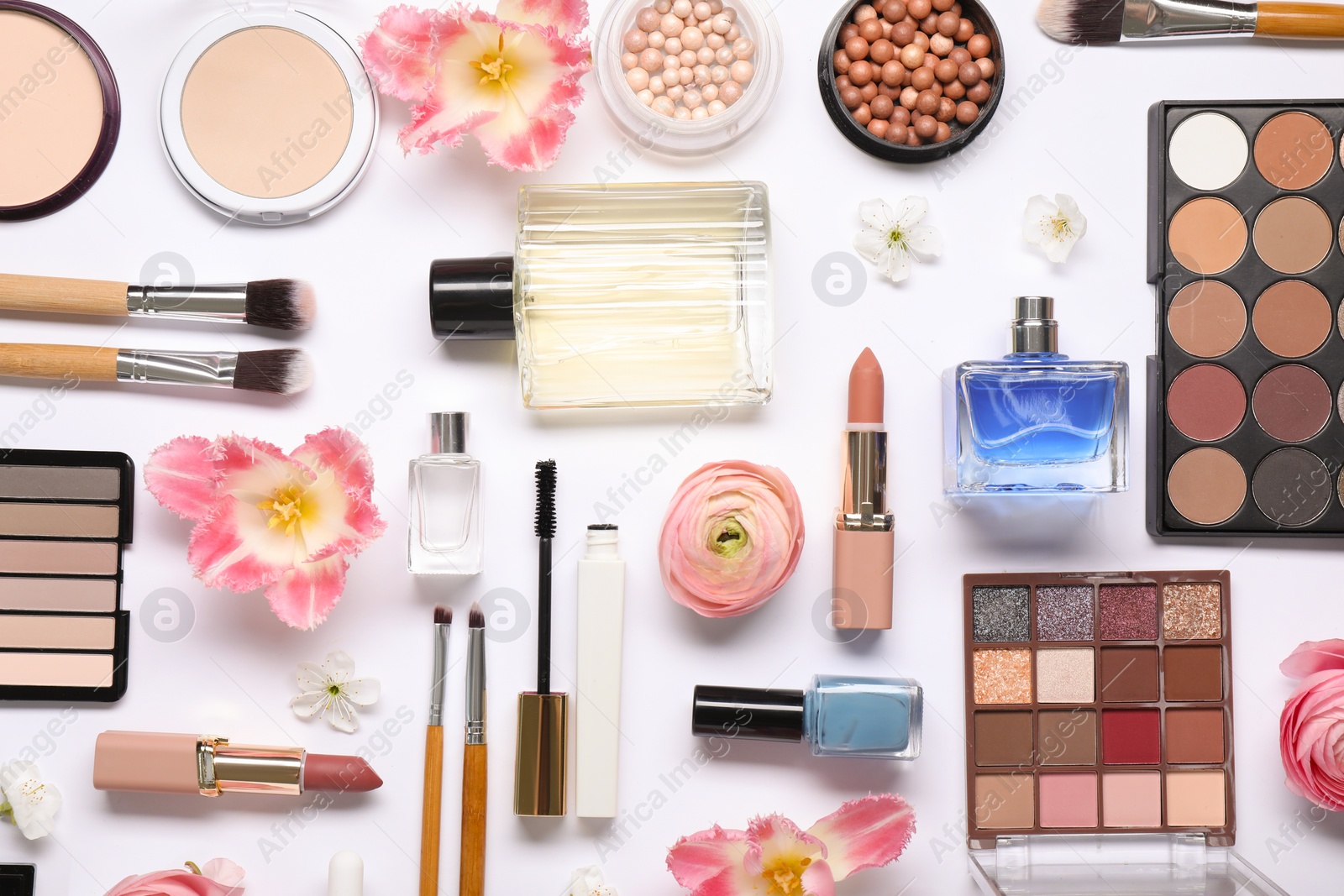 Photo of Flat lay composition with different makeup products and beautiful spring flowers on white background