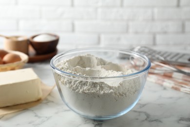 Photo of Making shortcrust pastry. Flour in bowl and butter on white marble table