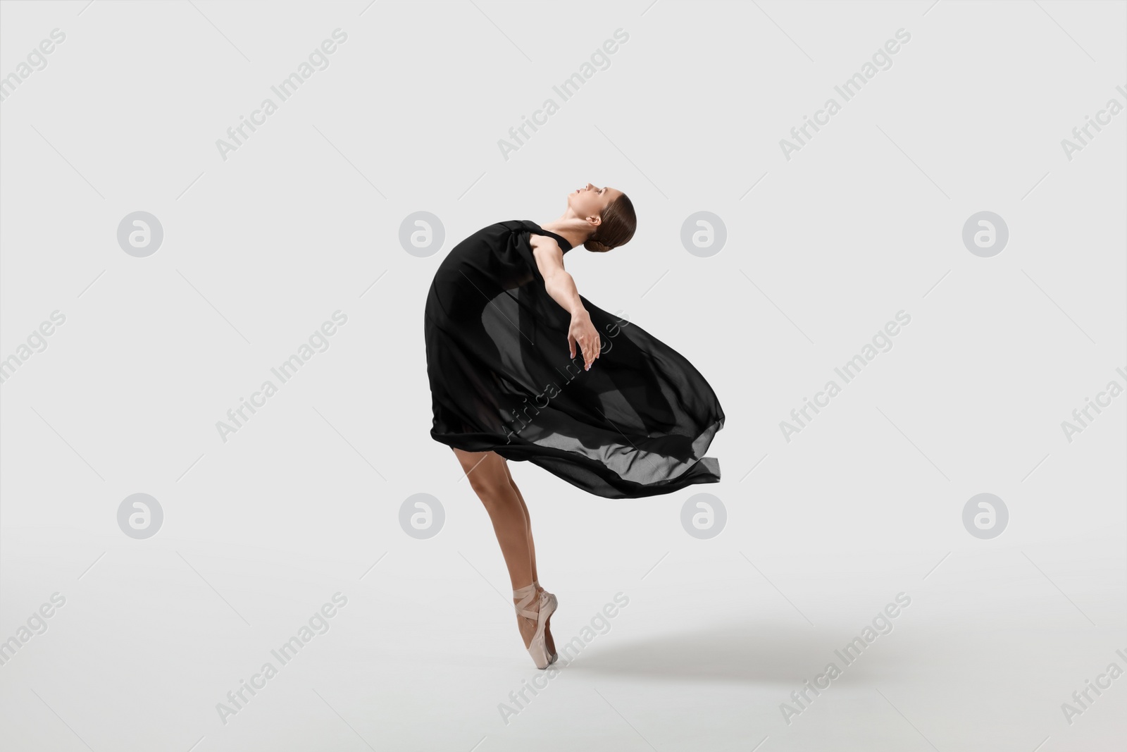 Photo of Young ballerina practicing dance moves on white background