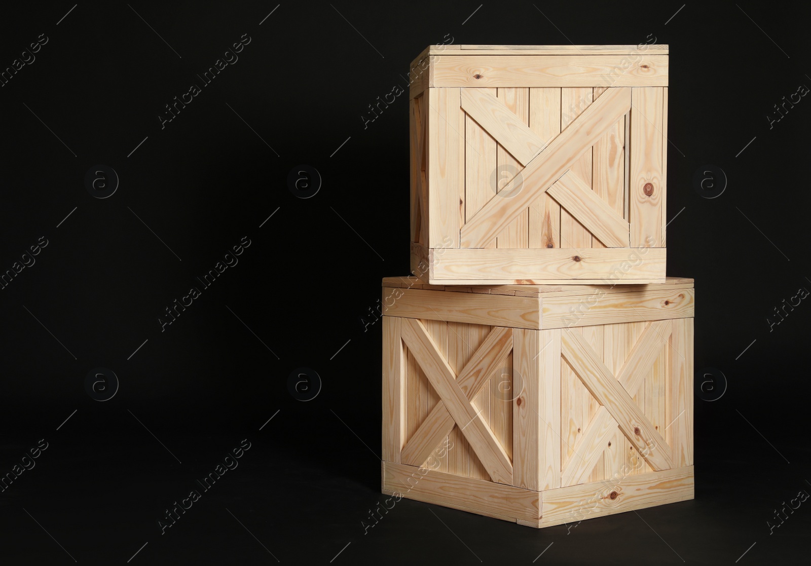 Photo of Wooden crates on black background. Space for text