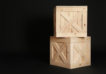 Photo of Wooden crates on black background. Space for text