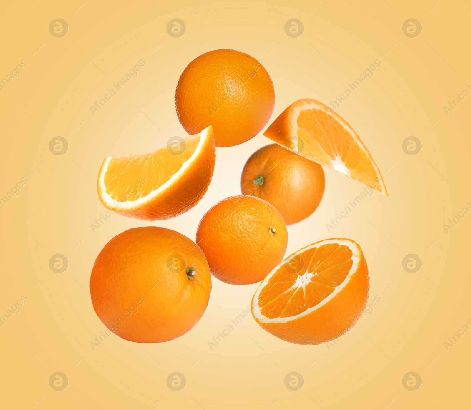 Image of Cut and whole oranges flying on pale orange background