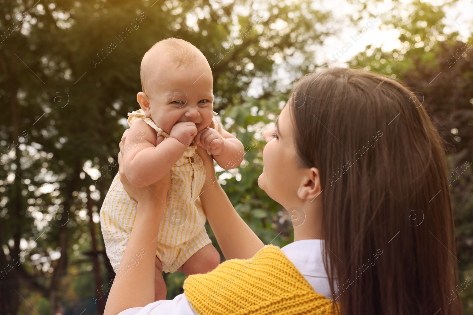 Photo of Happy mother with adorable baby walking on sunny day