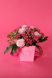 Photo of Beautiful bouquet of flowers in paper gift box on color background