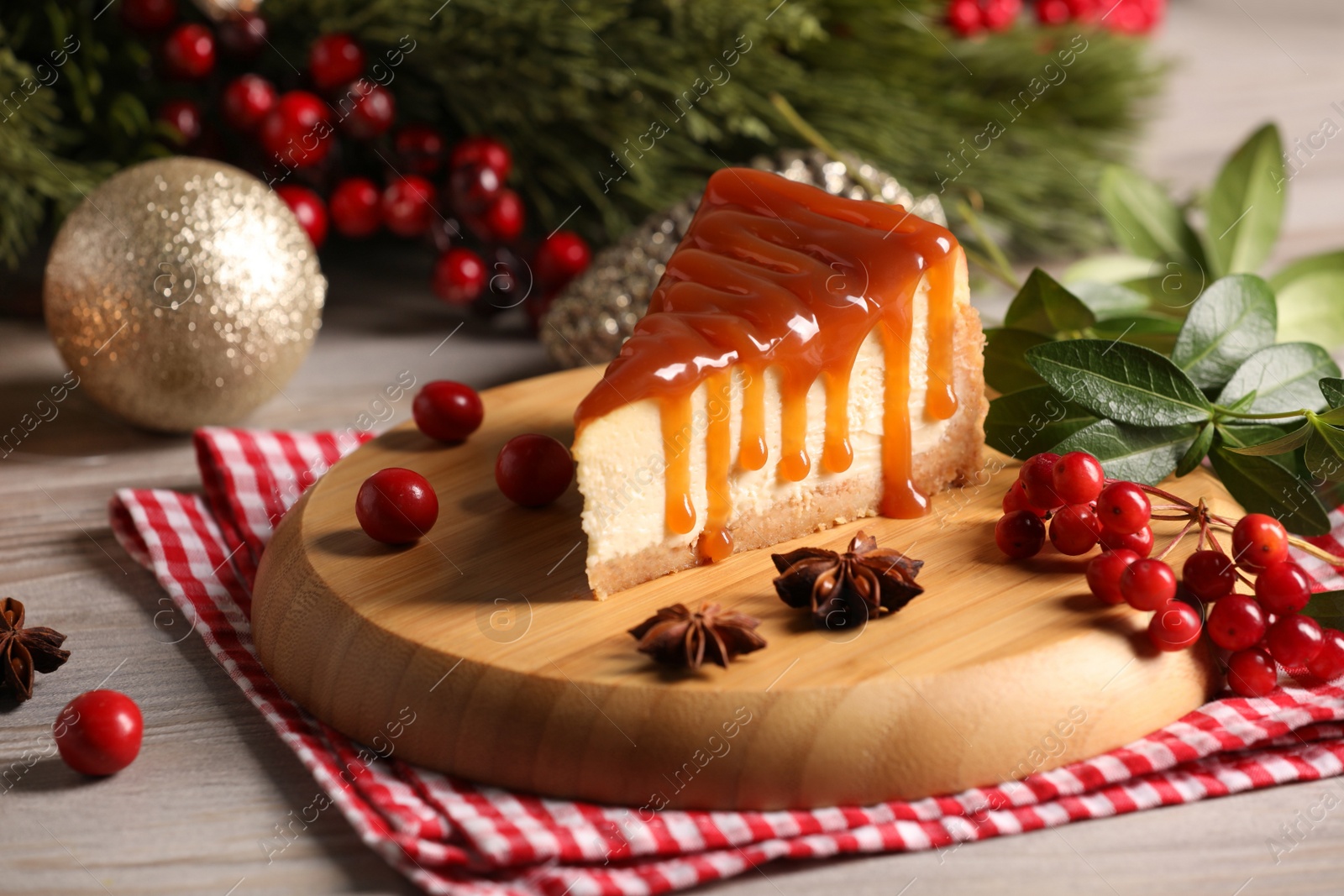 Photo of Tasty caramel cheesecake and Christmas decorations on wooden table