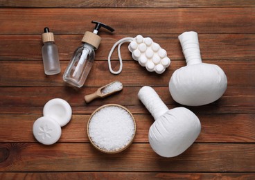 Photo of Flat lay composition of herbal bags and spa products on wooden table