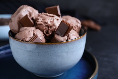 Photo of Yummy chocolate ice cream in bowl on table, closeup