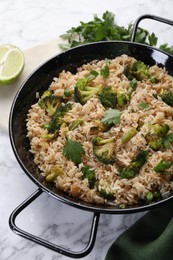 Photo of Tasty fried rice with vegetables served on white marble table, closeup