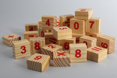 Photo of Wooden cubes with numbers and mathematical symbols on light background