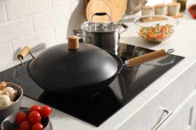 Photo of Frying pan with lid on cooktop in kitchen
