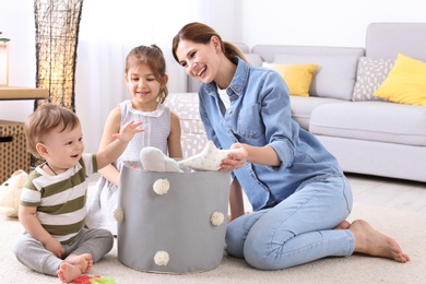 Housewife and children picking up toys after playing at home