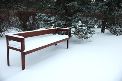 Bench covered with snow in city park