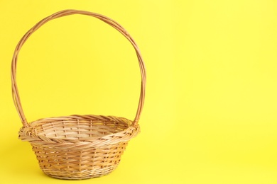 Empty wicker basket on color background, space for text. Easter item