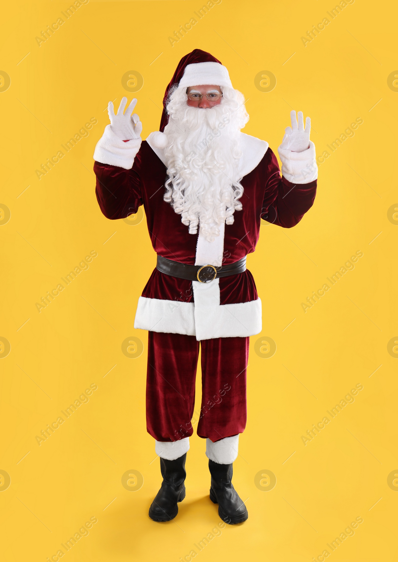 Photo of Full length portrait of Santa Claus on yellow background