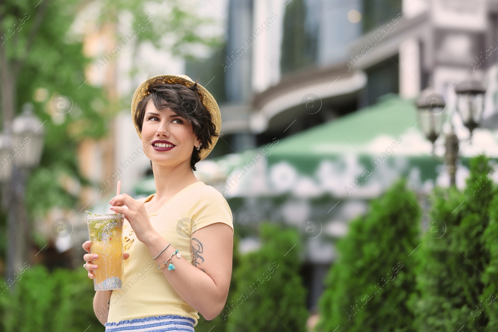 Photo of Young woman with cup of tasty lemonade outdoors