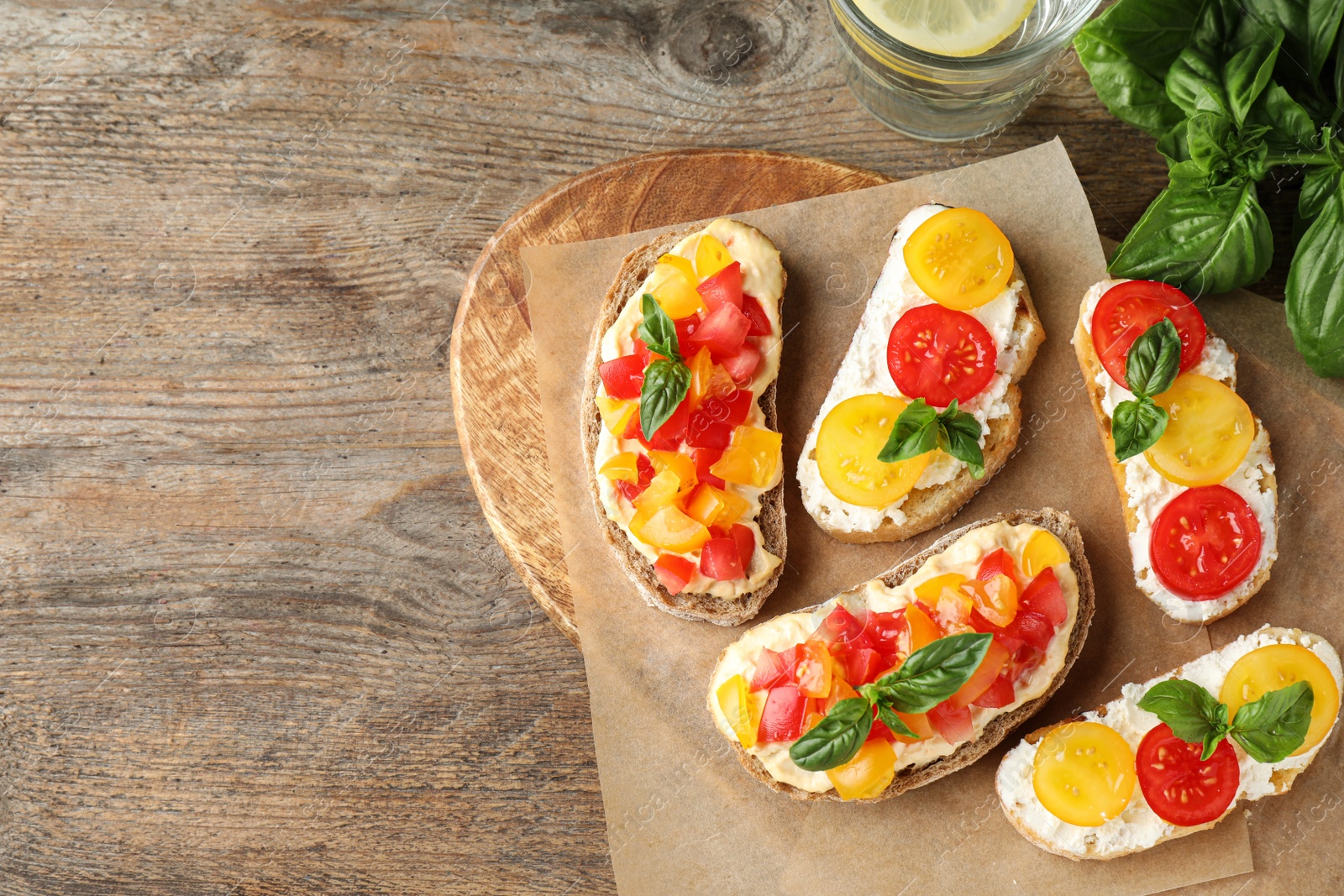 Photo of Tasty fresh tomato bruschettas on wooden table, flat lay. Space for text