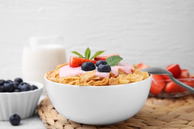 Delicious crispy cornflakes, yogurt and fresh berries in bowl on table, closeup with space for text. Healthy breakfast